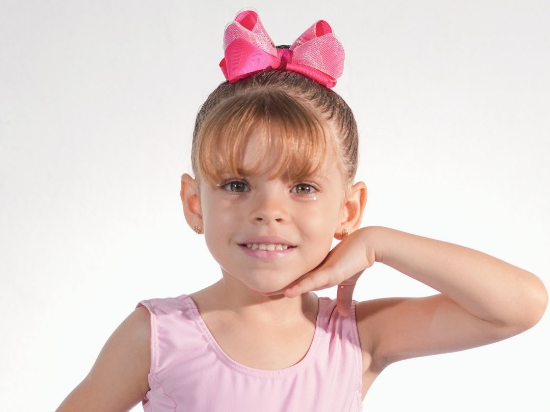 Aluna da Erlach Kids com collant e laço, pronta para a aula de balé