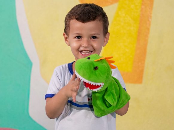 Aluno da Erlach Kids brincando com um fantoche na aula de teatro